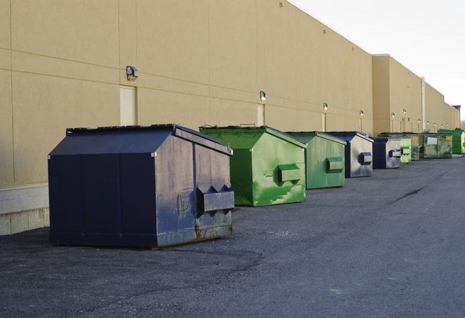 construction workers toss wood scraps into a dumpster in Isola MS